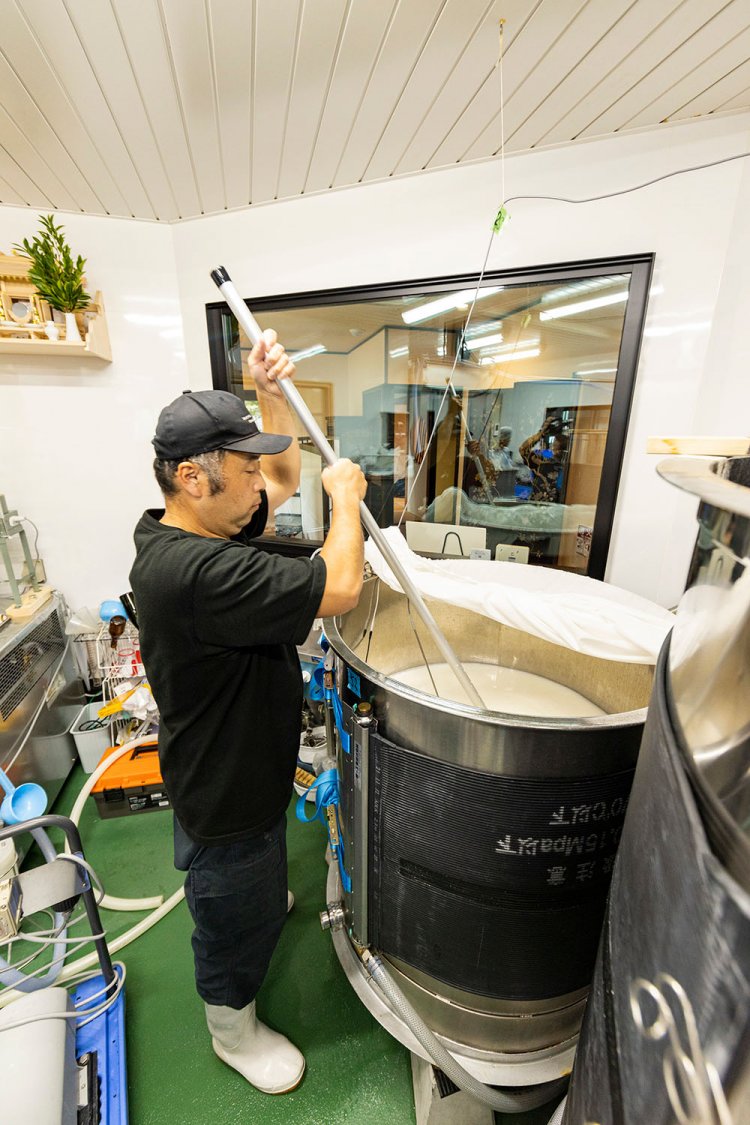 醸造所で櫂入れする磯崎さん。