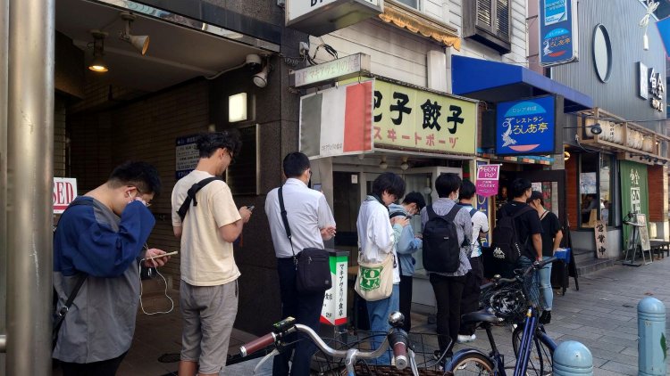 20日のランチタイムの行列（12時50分ごろ）。手前の黄色い看板は2020年6月に惜しまれつつ閉店した餃子の老舗「スヰートポーヅ」の遺構。