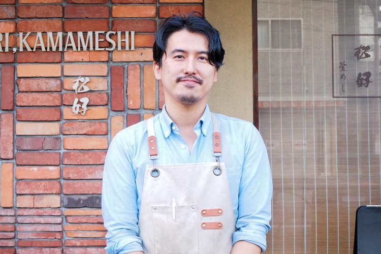店の前に立つ松井さん。