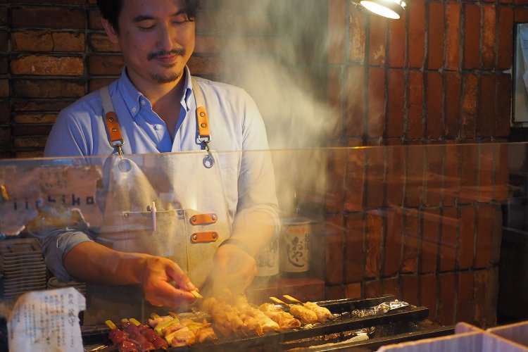 カウンターで焼き鳥を焼く松井さん。このおいしい煙も焼き鳥屋の醍醐味！