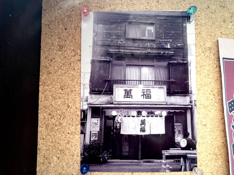 店の入り口に飾られている、昭和に建てられた木造の旧店舗の写真。