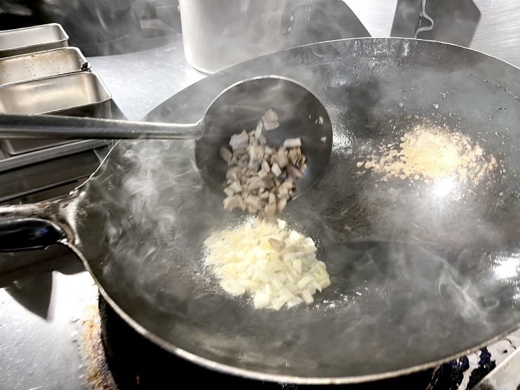 煙が出るくらいまで熱した中華鍋で、タマネギと荒く刻んだ自家製チャーシューを炒めていく。