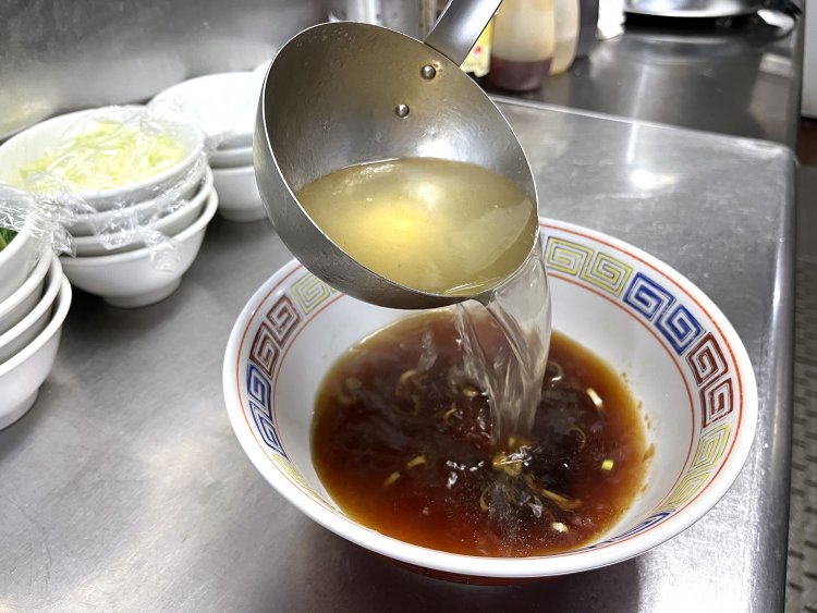 チャーシューのたれをかえしに使用し、秘伝のスープを丼に注ぐ。