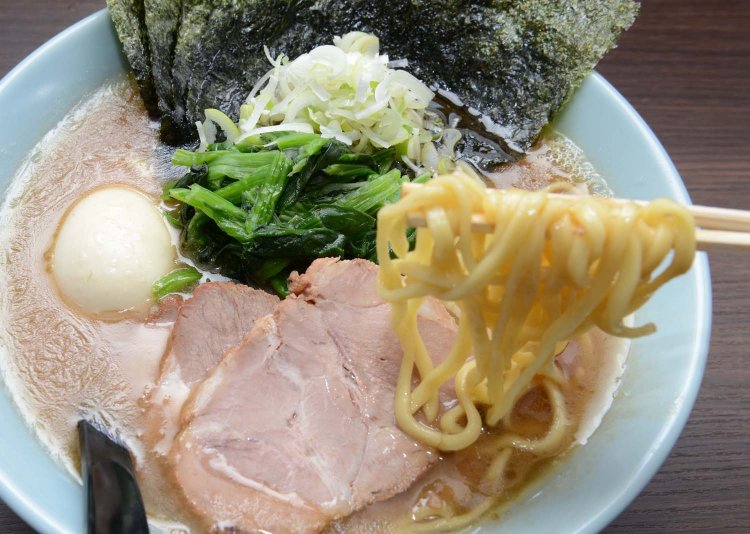 とろみがあるスープを持ち上げる中太麺。