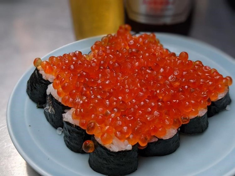 並んだ海苔巻きに大量にのせられたイクラ。