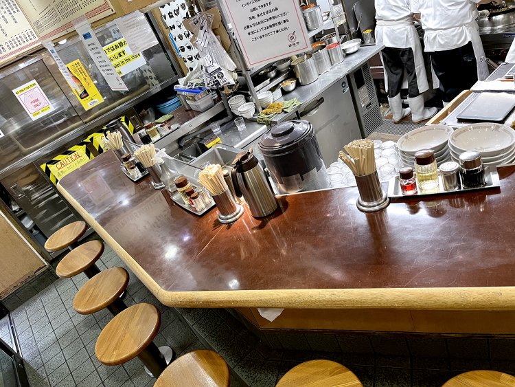 味わいのあるコの字カウンター。オーダーの比率は定食6：麺3：つまみ1くらいだとか。