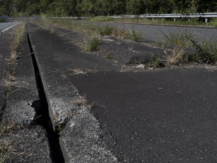 溝部分に近寄ってみる。この場所は車が行き来しない空間となっている。徒歩で中央分離帯へ近づけられるのも廃道になっているからだ。