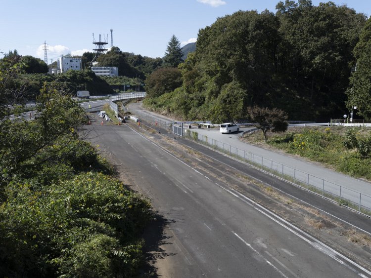 跨道橋から眺める光景。奥が現在線。付け替えの分岐部分が見える。白い車が走るあたりが一般道として再生された廃道の出発点となる。