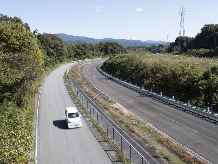 反対側（上野原IC側）を見る。白い車が走る部分が旧上り線を活用した生活道路で、旧下り線はNEXCO中日本の管理用として立ち入りとなり、そのため廃道時の面影が色濃く残っている。
