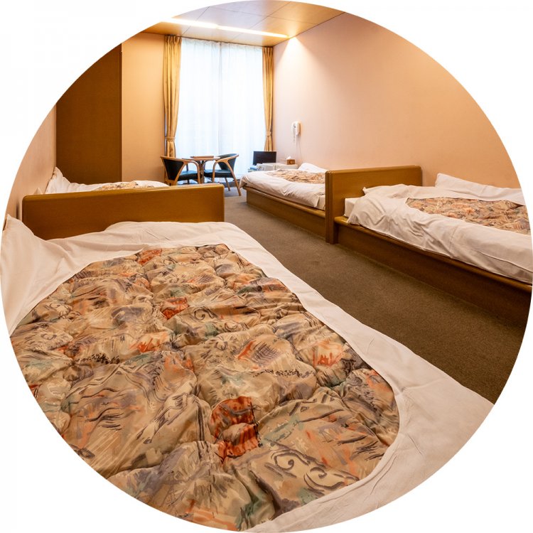 宿泊棟の4人用洋室。通常期1泊2食付き6400円～。