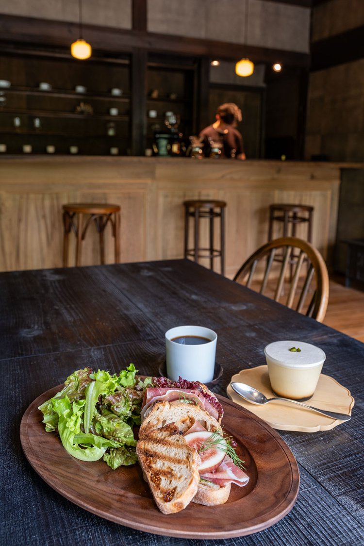 藤崎さんが手がけた木の皿で提供される季節のサンド1200円（手前）と珈琲の為のプリン500円（右奥）。珈琲は500円。