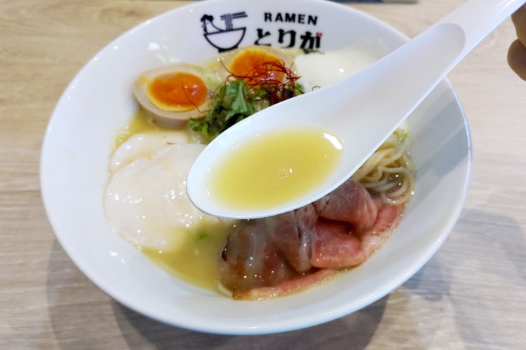 ほんのり白濁した黄色い鶏白湯スープ。コラーゲン豊富でクリーミーであると同時に、キレもある。