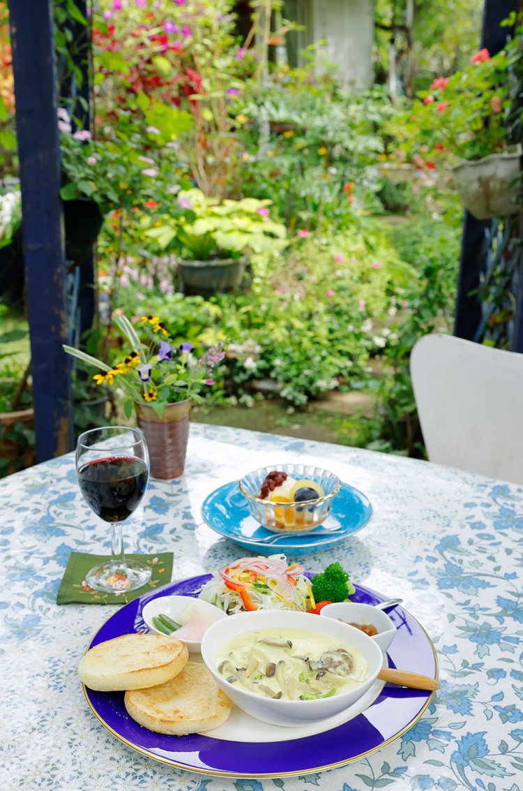 ツバキの木陰席は建物がのぞき見える人気席。手ごねハンバーグはカレーがほんのり香るホワイトソース仕立て。お食事セットのオリジナルハンバーグ1300円（コーヒーか紅茶付き）。