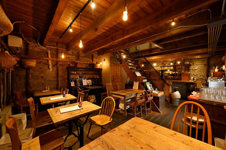 築100年を超える石蔵をリノベーションしており、内装はむき出しになった石壁やアンティークショップで買い付けた家具など、モダンな雰囲気がたっぷり。一人客も多く訪れる。