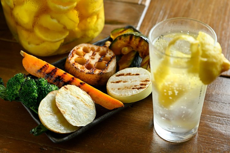 自家製瀬戸内レモンサワー880円（手前）。農場やさいグリル1320円（奥）は岩塩とオリーブオイルのみで味付け。