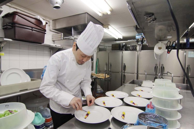 盛り付け作業中の料理長・西 修平さん。料理の腕前はもちろん、探究心の強さにも感心する。