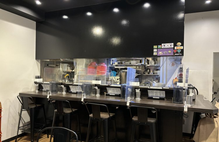 外観と同じく、黒を基調とした店内。客席にはラーメンへのこだわりを知ることができる説明書きも。