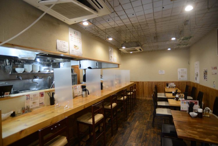 木の温もりを感じさせる店内。カウンター席からはラーメンを作る様子を見られる。