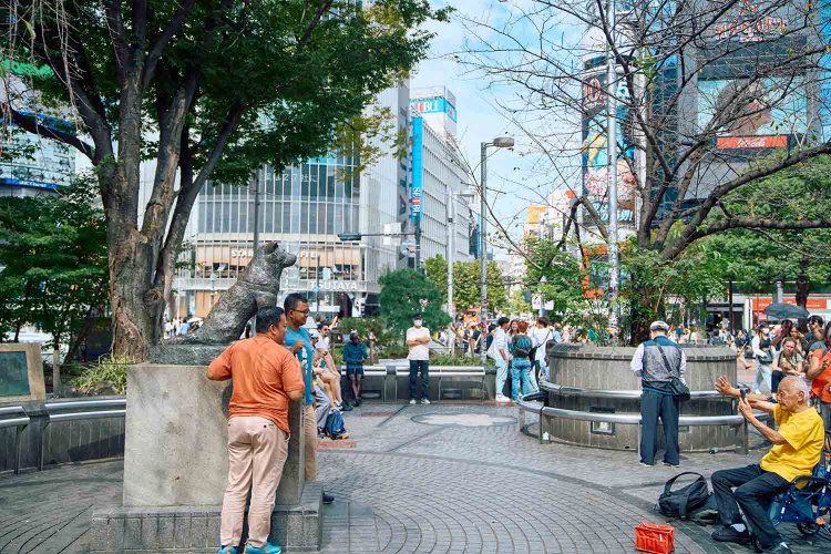 ハチ公と記念撮影をする外国人観光客。