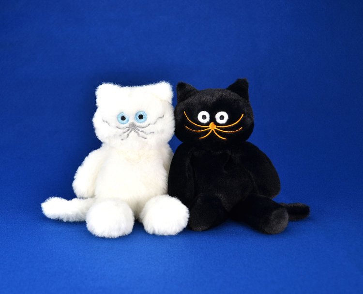 .ふわふわな毛並みが特徴的なしろねこと、ツヤっとしたオレンジのヒゲのくろねこのぬいぐるみ各3300円。