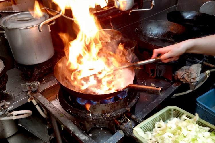 中華鍋にモヤシやキャベツなどの野菜を投入すると、豪快な火柱が。こちらまで熱気が伝わってくる。