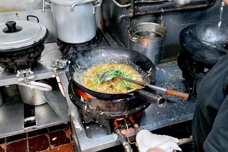 具材のニラを入れるのは最後。軽く炒めたら盛り付けへ。すべての動作がスピーディかつ無駄がない。