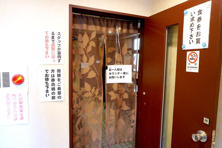 のれんをくぐる前に券売機で食券を購入し、壁際に並んで案内されるのを待つ。