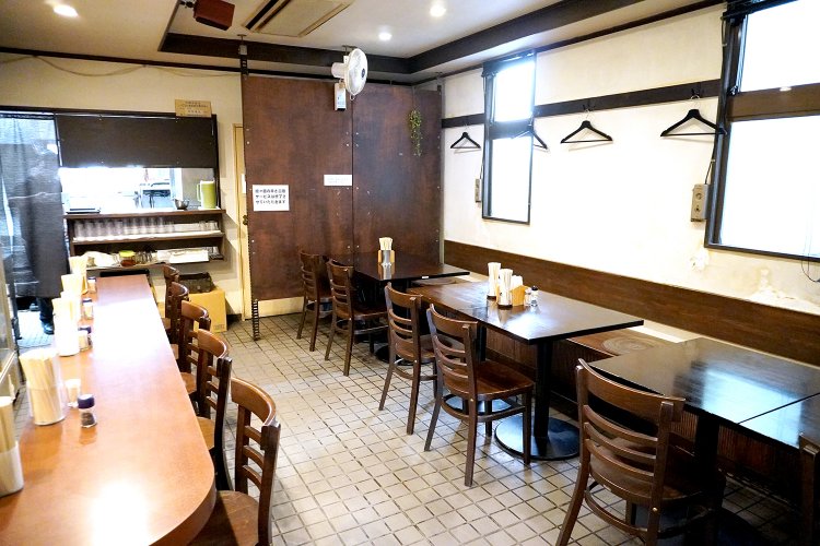 カウンター7席、4人掛けテーブル3席。かつては宿泊客専用の食堂だった。