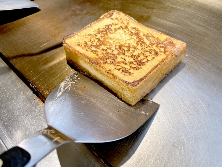 卵や牛乳などに一晩漬け込んだ食パンを鉄板でこんがりと焼く。