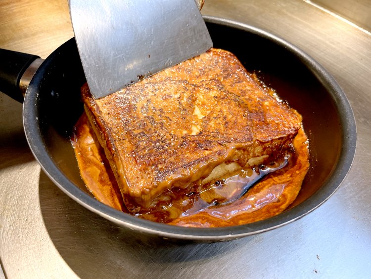 三温糖と水を煮詰めたフライパンに先ほどのパンを入れ、全体をキャラメリゼする。