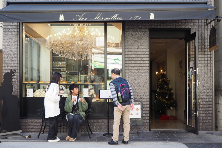 『Aux Merveilleux de Fred』の軒先で、お店が気になる方と言葉を交わす2人。