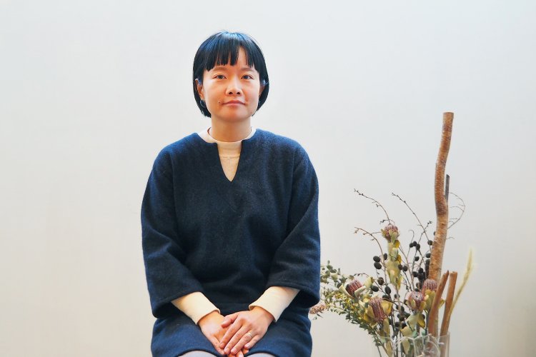 ギャラリースペースに座る顧さん。