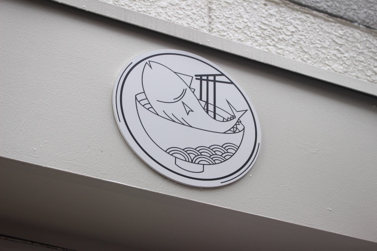 看板に掲げられた『うどん鈴木鰹節店』のマーク。まさに鰹を食ううどん！