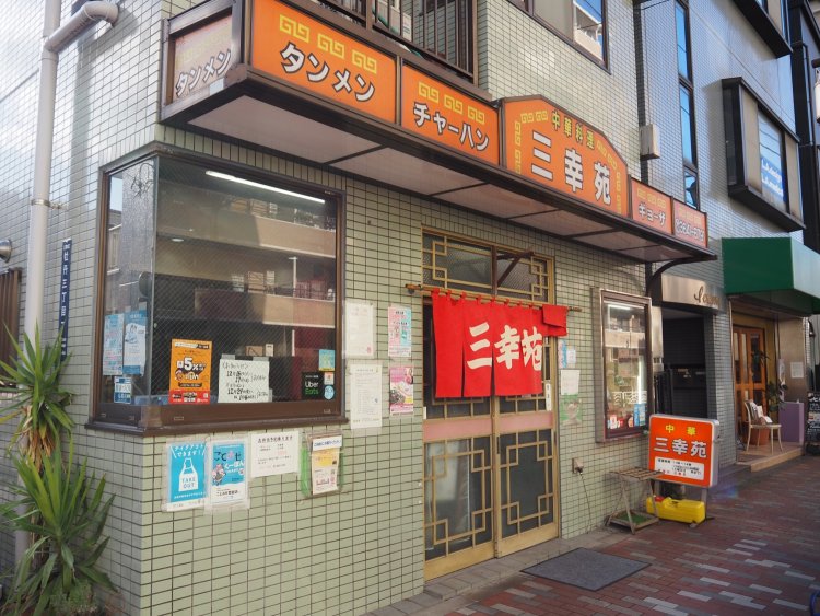 赤い暖簾（のれん）がぱっと目を引く店構え。外観から既にどこか懐かしい雰囲気が感じられる。