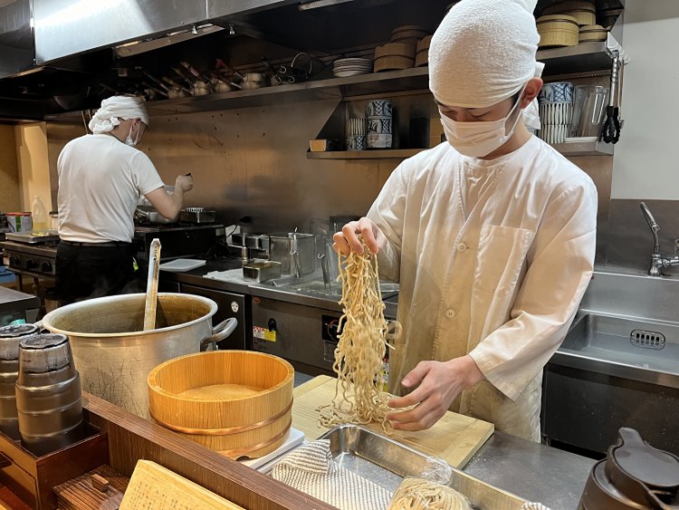 特製麺の手揉みをする谷口さん。