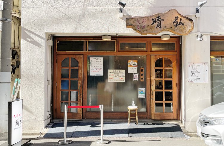 一枚板の看板が存在感を放つ外観。