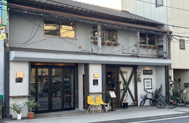 木材と灰色の壁が特徴のかわいらしい外観、夜には屋根に付けられたオレンジのライトが光る。