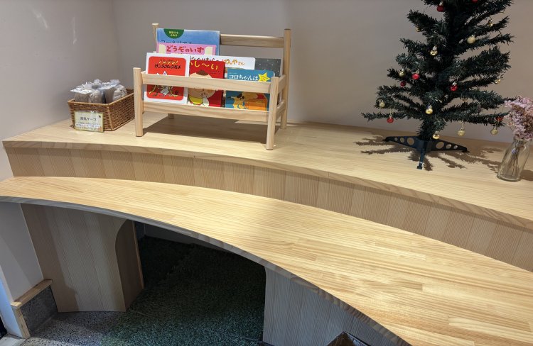 木製のカウンター席には絵本が並び、季節に合わせた飾りも。カウンター下には子どもの遊び場としてトンネルも！