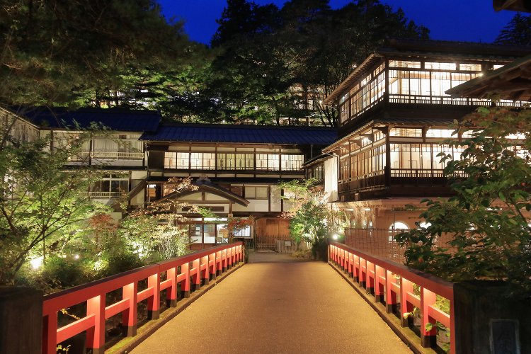 夕暮れに本館をライトアップ。近くの宿から記念撮影に来る人も多い。