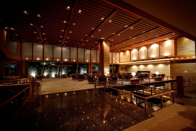 開放的なロビーラウンジ「山草花」。夜には庭園を流れる滝がライトアップされる。