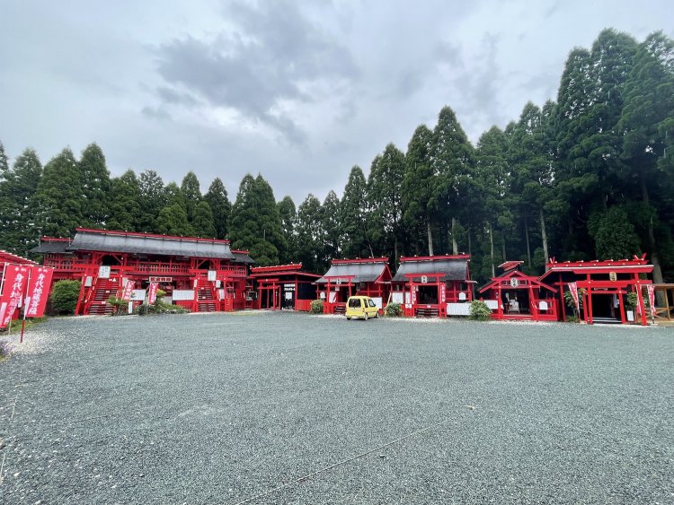 阿蘇の雄大な自然の中に立ち並ぶ朱塗りの建物。