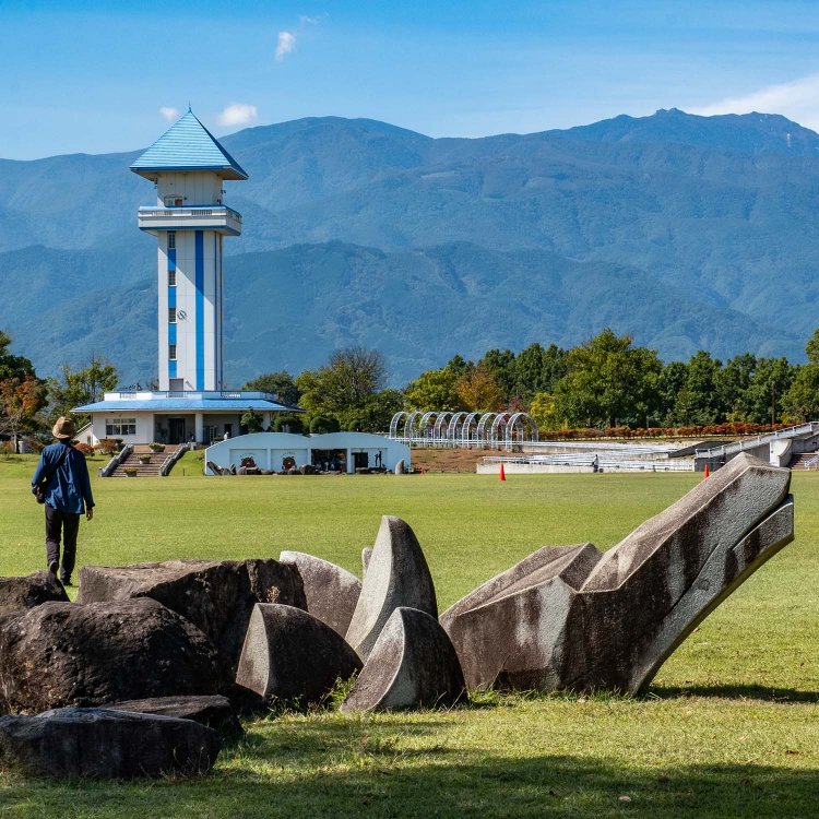 園内には龍を模した岩のモニュメントも。右奥は南アルプス鳳凰三山の一座・薬師岳。