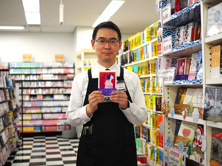店長の佐々木さん。売れ筋の地元本『洲崎パラダイス』と。