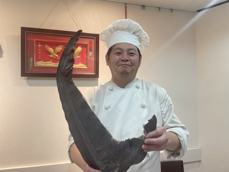 フカヒレを持ち、笑顔の諸永さん。その顔は料理人としての矜持に満ちあふれている。