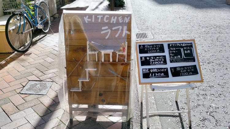 立て看板には店名だけでなく、ミニチュアのテーブルと椅子、階段が。その意味は2階に上がるとわかる。