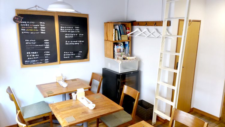 カウンターのみの1階に対して、2階には2人掛けのテーブル席が4つ。本棚には主に絵本が並んでいる。