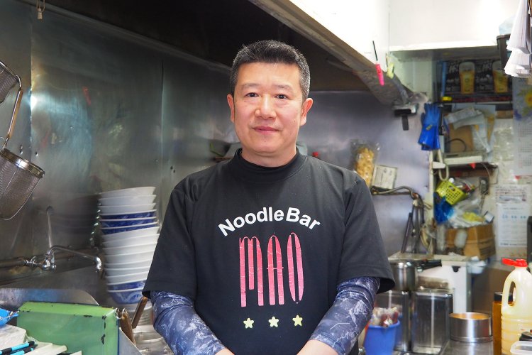 厨房に立つ劉さん。