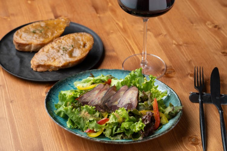 『カネサ鰹節商店』の潮かつおを使った生ハムサラダ770円、特製ガーリックトースト2個550円。