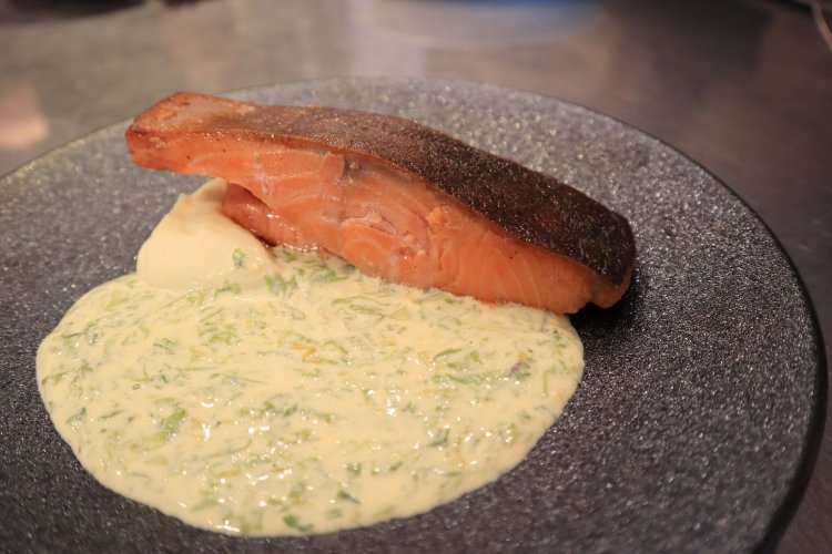 本日の魚料理。クールなダーク系の皿に、サーモンの身の色が映える。