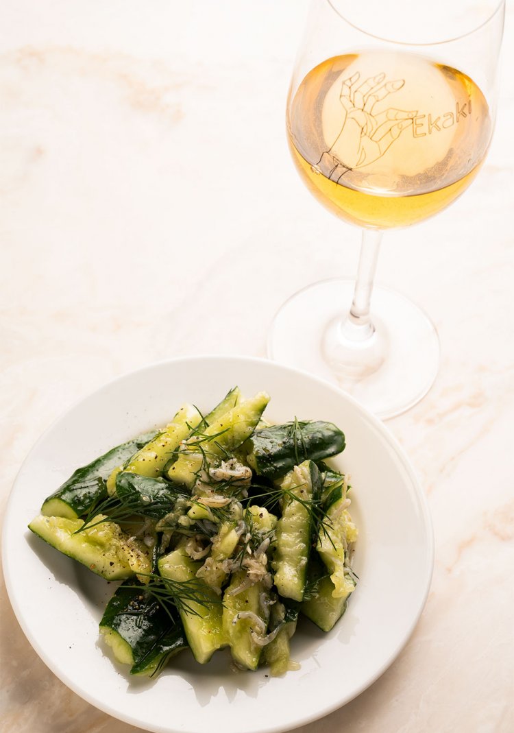 キュウリしらすディルのサラダ500円は、やさしくうまみのあるオレンジワインと。華やかさと果実味が調味に使ったレモン、ナンプラーに合う。